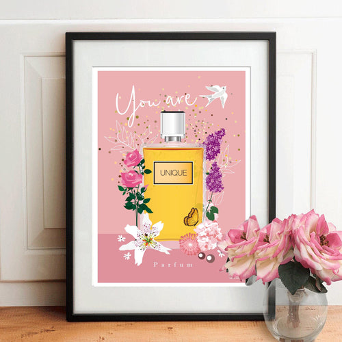 Affiche décorative encadrée avec bouteille de parfum jaune et fleurs sur fond rose