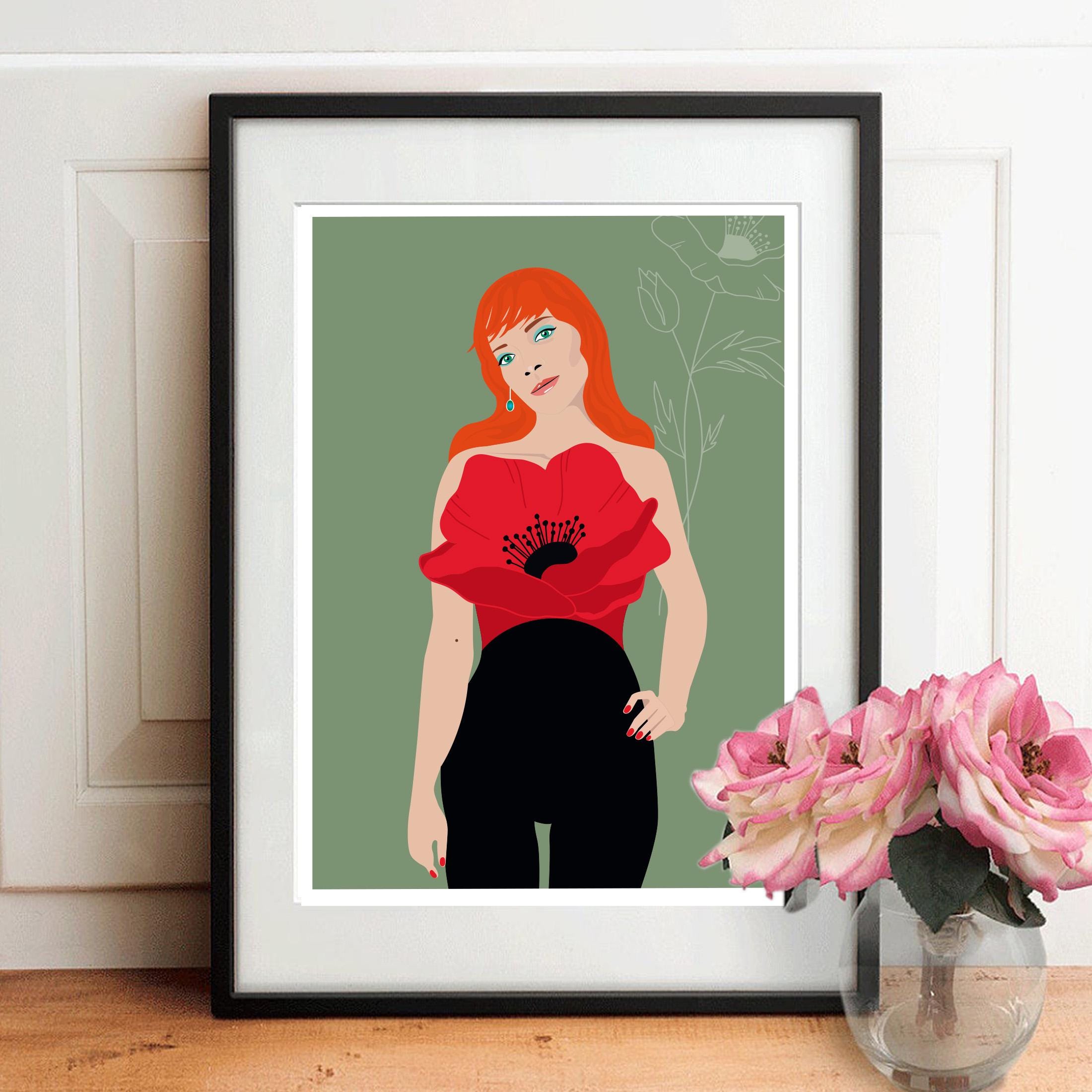 Affiche encadrée : femme aux cheveux roux, robe rouge coquelicot, pantalon noir.
