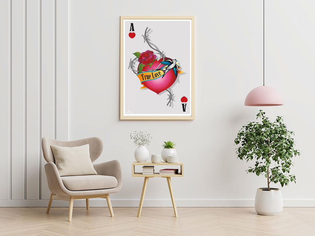 Affiche cœur tatoué avec rose rouge et oiseau bleu, encadrée beige sur mur clair.