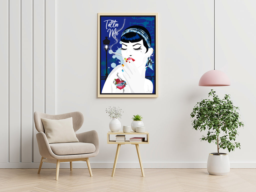 Affiche encadrée pin-up aux tatouages, fond bleu, sur mur clair