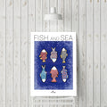 Affiche encadrée montrant plusieurs poissons stylisés sur fond bleu, « FISH AND SEA »