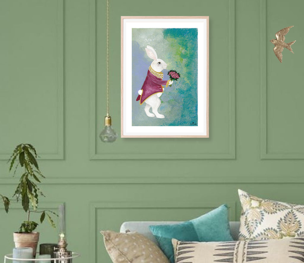 Affiche encadrée d’un lapin blanc en manteau bordeaux tenant un bouquet, fond bleu-vert.