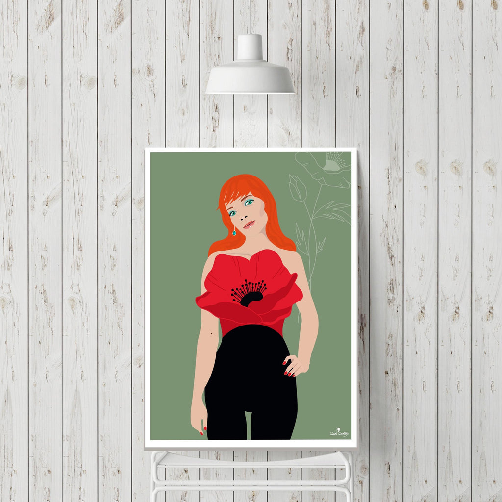 Affiche encadrée : femme aux cheveux roux, robe rouge à motif coquelicot, pantalon noir.
