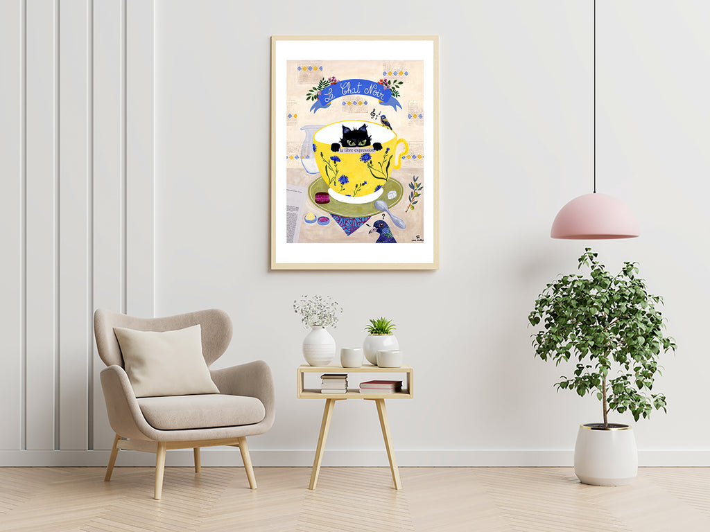 Affiche encadrée : chat noir dans une tasse jaune, rubans et fleurs bleues.