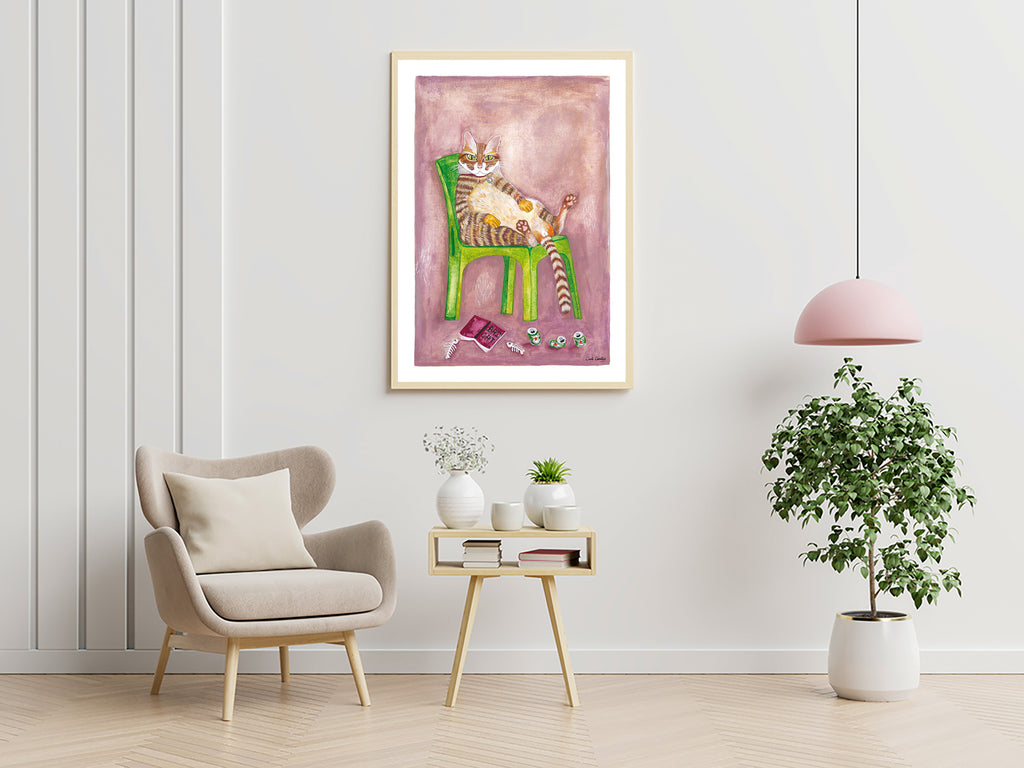Affiche encadrée d’un chat roux sur chaise verte, fond mauve, livre et souris.